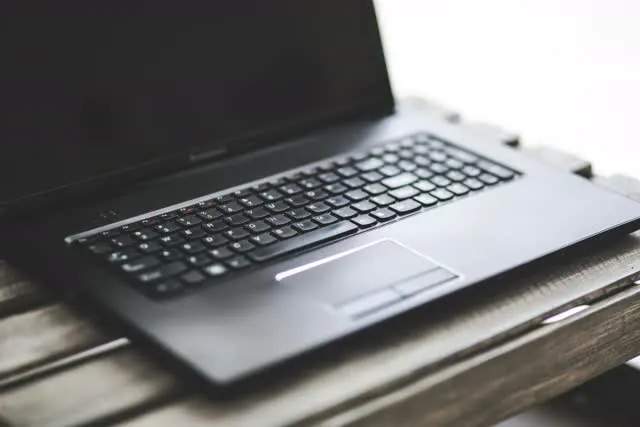 Black laptop opened on top of table